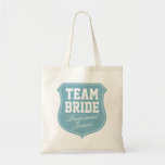 Turquoise Team Bride tote bags for wedding party<br><div class="desc">Turquoise Team Bride tote bags for wedding party. Personalizable with name. Cute gift idea for bride,  bridesmaids,  maid of honour,  mom,  sister,  friends etc. Pink emblem badge design for wedding party,  bridal shower,  bachelorette girls night out. Elegant script letters. Turquoise blue and white colours.</div>