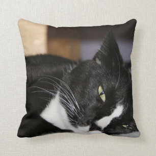 tuxedo cat black and white lying down one eye open throw pillow