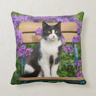 Tuxedo cat sitting on a garden chair with flowers throw pillow