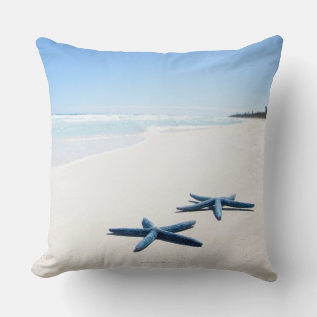 Two blue starfish at water's edge on tropical 2 throw pillow (Front)