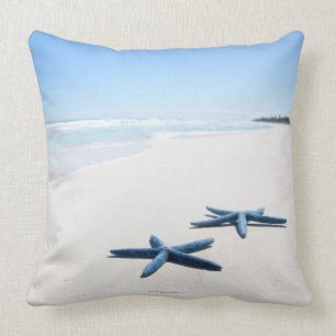 Two blue starfish at water's edge on tropical 2 throw pillow