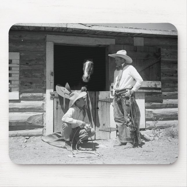 Two cowboys standing next to a barn with a horse mouse pad (Front)