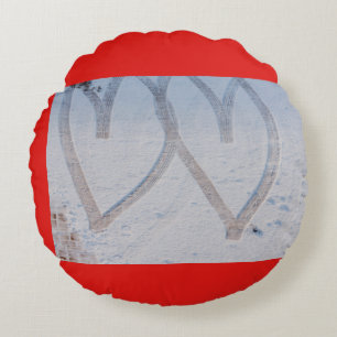 two hearts drawn in the snow on round pillow
