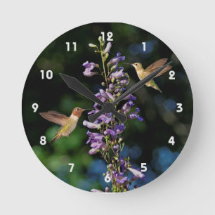 Two Hummingbirds In Flight With Flowers Wall Clock