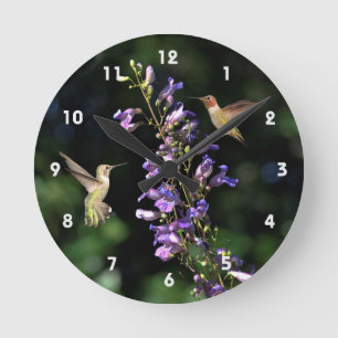 Two Hummingbirds In Flight With Flowers Wall Clock