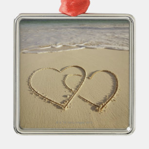 Two overlying hearts drawn on the beach metal ornament