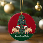 Two Pug Christmas Dogs in Santa Hat Cute Custom Ceramic Ornament<br><div class="desc">This beautiful monogrammed Christmas ornament features a cute pug wearing a Santa Claus hat in front of a pretty Christmas tree decorated with colourful ornaments. Personalize with a pet owner name in lovely cursive under the wonderful drawing.</div>