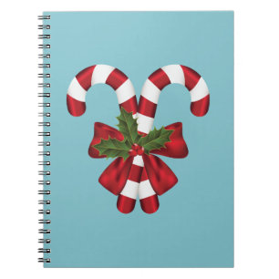 Two Red And White Festive Candy Canes On Blue Notebook