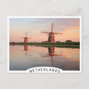 Two windmills with reflection at sunset postcard