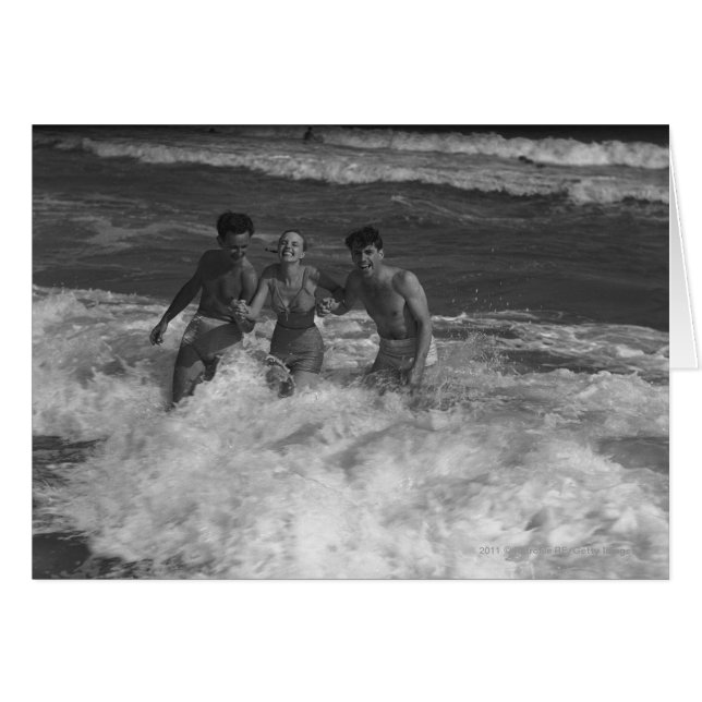 Two young men and woman playing in wave B&W (Front Horizontal)