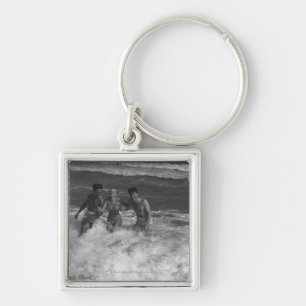 Two young men and woman playing in wave B&W Keychain