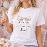 Tying the knot ivory bow pearls Bachelorette T-Shirt<br><div class="desc">Elevate your bridal events with this sophisticated coquette-themed party collection. Each piece showcases a high-fidelity ivory bow paired with delicate pearl accents and timeless typography. This set is perfect for the modern bride wanting a cohesive look for her bachelorette trip and bridal shower.</div>