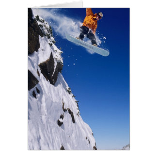 Un homme en snowboard sautant d'une corniche à