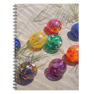 USA, Oregon. Colourful Glass Floats On Sand Dune Notebook