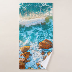 Vagues sur une plage rocheuse au coucher du soleil