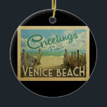 Venice Beach Vintage Travel Ceramic Ornament<br><div class="desc">This Greetings From Venice Beach vintage postcard design features a sandy beach with a beautiful turquoise ocean water and above the sea,  a blue sky with billowy white clouds. In vintage travels style.</div>