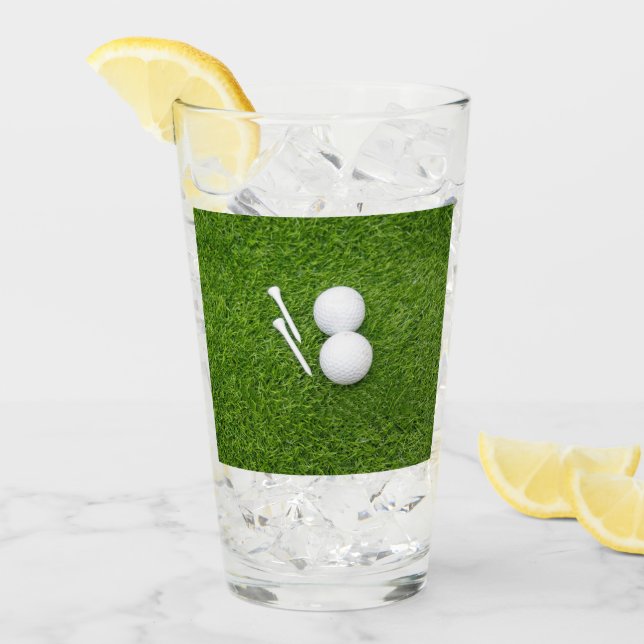 Verre Golf ball et tee sont sur herbe verte (Devant glace)