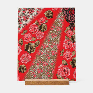 Vibrant red fabric featuring intricate floral and  acrylic sign