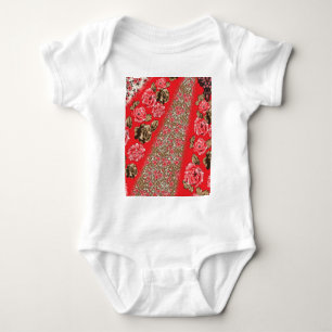 Vibrant red fabric featuring intricate floral and  baby bodysuit