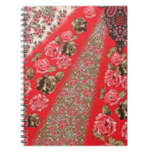 Vibrant red fabric featuring intricate floral and  notebook