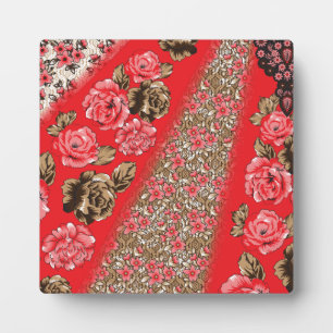 Vibrant red fabric featuring intricate floral and plaque
