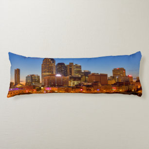View of the city skyline at dusk body pillow