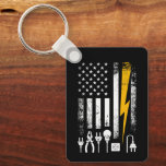 Vintage American Flag Lineman Electrician Tools Keychain<br><div class="desc">Whether they’re climbing poles in a storm or maintaining the grid, an electrician’s job is never done. This distressed, patriotic design on a keychain celebrates the skill and bravery of powerline workers. Featuring a retro aesthetic with a focus on the tools of the trade and the Stars and Stripes, this...</div>