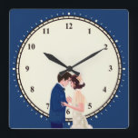 Vintage Glam 1920s Couple Numbers Dark Blue Square Wall Clock<br><div class="desc">Vintage twenties romance with this illustration of a 1920s glamorous couple,  with a cream backdrop and a dark blue around the edge,  with numbers and minutes. Also available as round.</div>