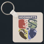 Vintage HOGWARTS™ Stamped Crest Keychain<br><div class="desc">Show your house pride in bold, vintage-inspired style with this striking Hogwarts™ crest design. Featuring graphic silhouettes representing the four iconic houses — Gryffindor™, Slytherin™, Hufflepuff™, and Ravenclaw™ — this artwork blends classic symbolism with a modern, retro aesthetic. Each house emblem is set within a clean, color-blocked shield, creating a...</div>