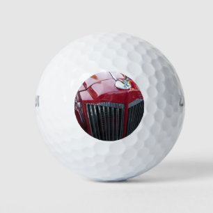 vintage red car with chrome hood ornament golf balls