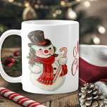 Vintage Retro Snowman Merry Christmas Coffee Mug<br><div class="desc">This coffee mug features a vintage retro snowman wearing a red scarf and black top hat while holding a sprig of holly and berries in one hand and a candy cane in the other. The words "Merry Christmas" in red decorative script is in the middle of the front and back...</div>