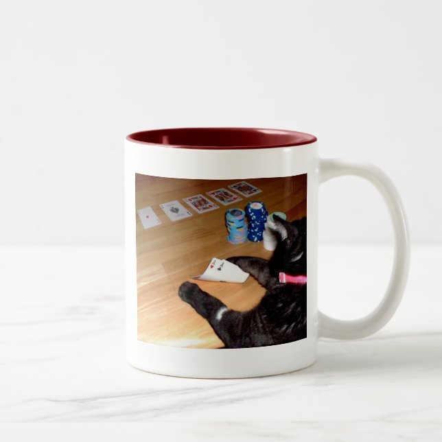 Vrai chat jouant la tasse de café de tisonnier (Droit)