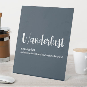 Wanderlust definition white grey blue colour  pedestal sign