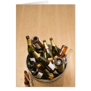 Waste bin full of empty champagne bottles on