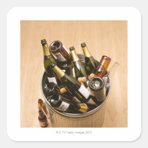 Waste bin full of empty champagne bottles on square sticker