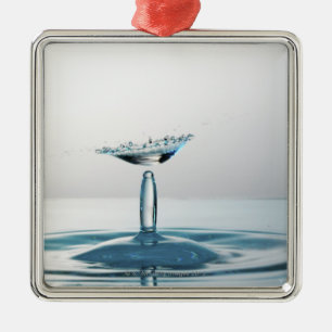Water drops colliding to shape an umbrella metal ornament
