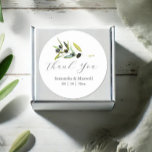 Watercolor Olive Branch Wedding Classic Round Sticker<br><div class="desc">Elevate your wedding favours with these elegant olive stickers, perfect for adding a touch of Italian charm to your special day. Featuring the words "Thank You" in trendy script typography, these stickers showcase a minimalist design adorned with a beautiful sprig of watercolor olive foliage. The botanical greenery offers a rustic...</div>