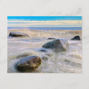 Waves crashing on shoreline rocks postcard