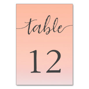 Wedding by the sea under peachy sky sunset table number