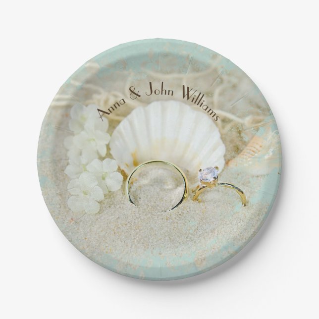 wedding rings and seashells in sand with net paper plate (Front)