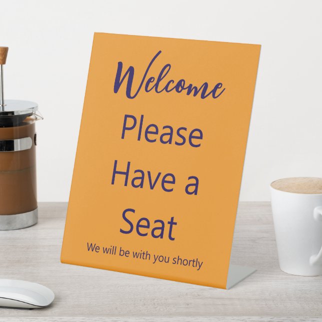 Welcome Please Have a Seat Orange and Blue Text Pedestal Sign (In SItu)