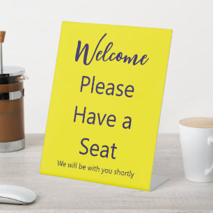 Welcome Please Have a Seat Yellow and Blue Text Pedestal Sign