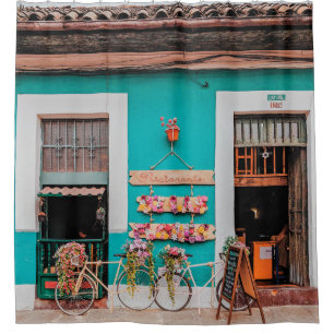 WHITE BICYCLE PARKED BESIDE TEAL PAINTED CONCRETE 