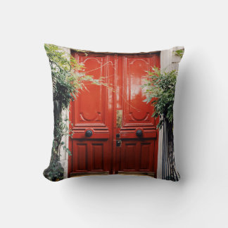 WHITE BUILDING SHOWING CLOSED RED WOODEN DOOR THROW PILLOW