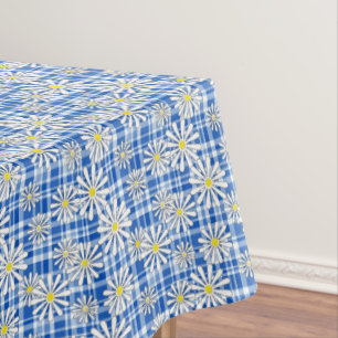 White chamomile flowers on a blue chequered backgr tablecloth