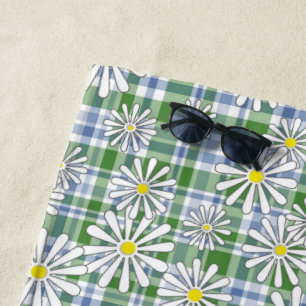 White chamomile flowers on a green blue chequered  beach towel