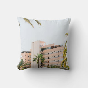 WHITE CONCRETE BUILDING BESIDE GREEN PALM TREE UND THROW PILLOW