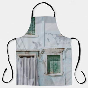 WHITE CONCRETE BUILDING WITH THREE GREEN WINDOWS A APRON