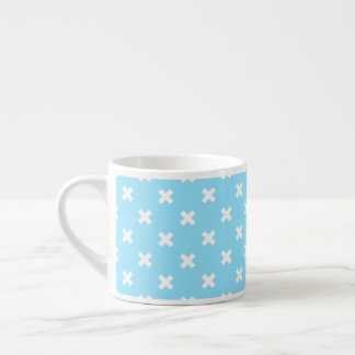 White cross stitches on baby blue espresso cup