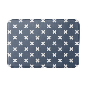 White cross stitches on blue-gray bath mat